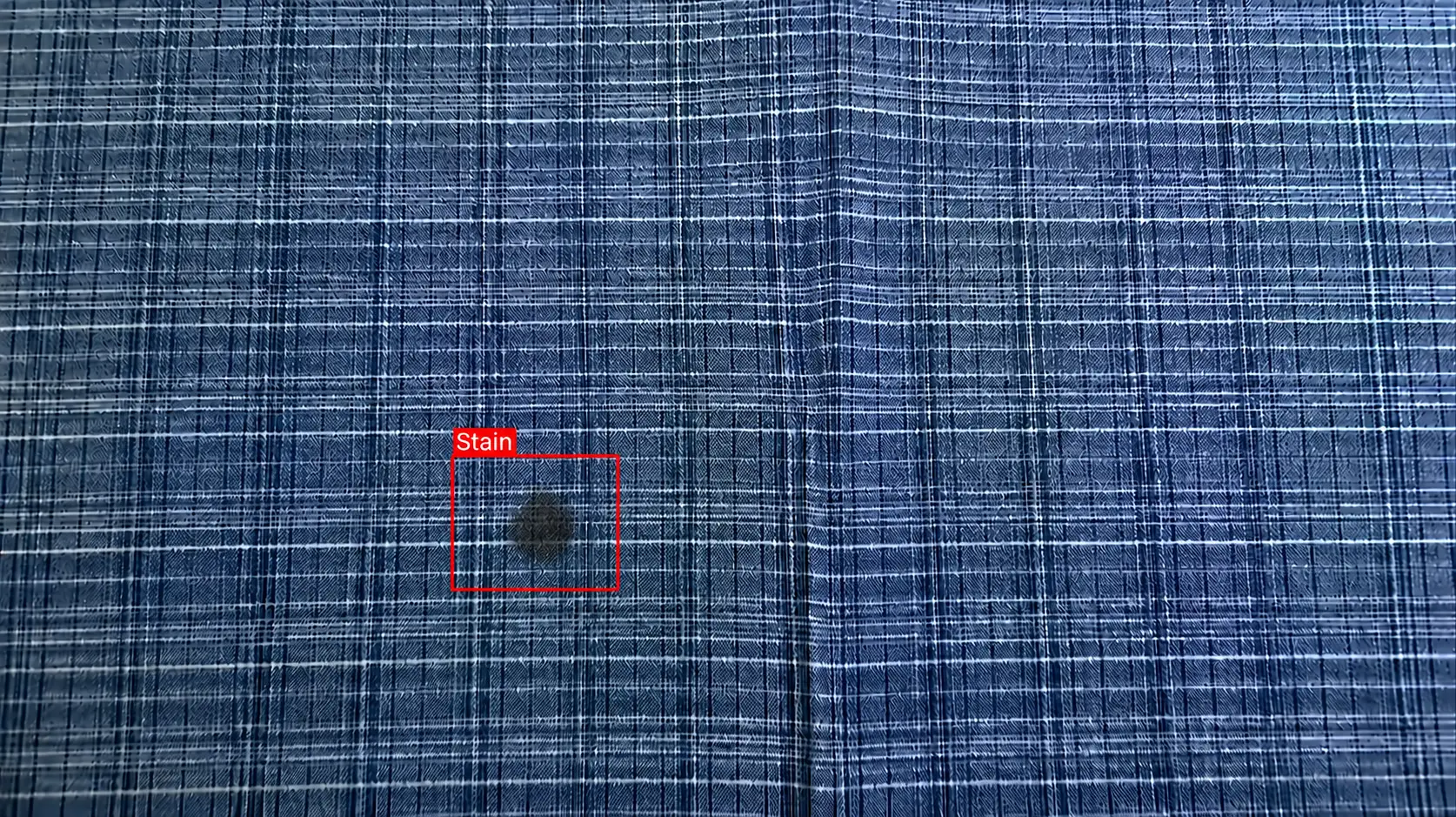 AI detecting a stain on patterned check fabric: catching a defect hidden in the pattern (Stain)