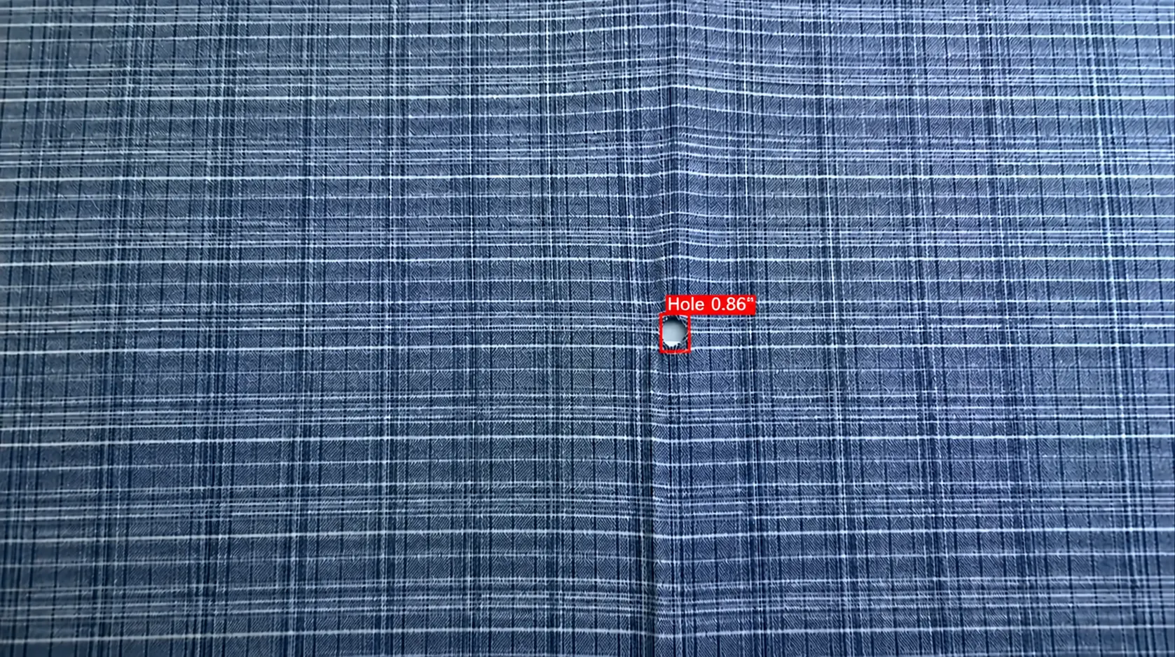 AI detecting a hole in textile fabric quality control: defect box and confidence score (Hole 0.86)